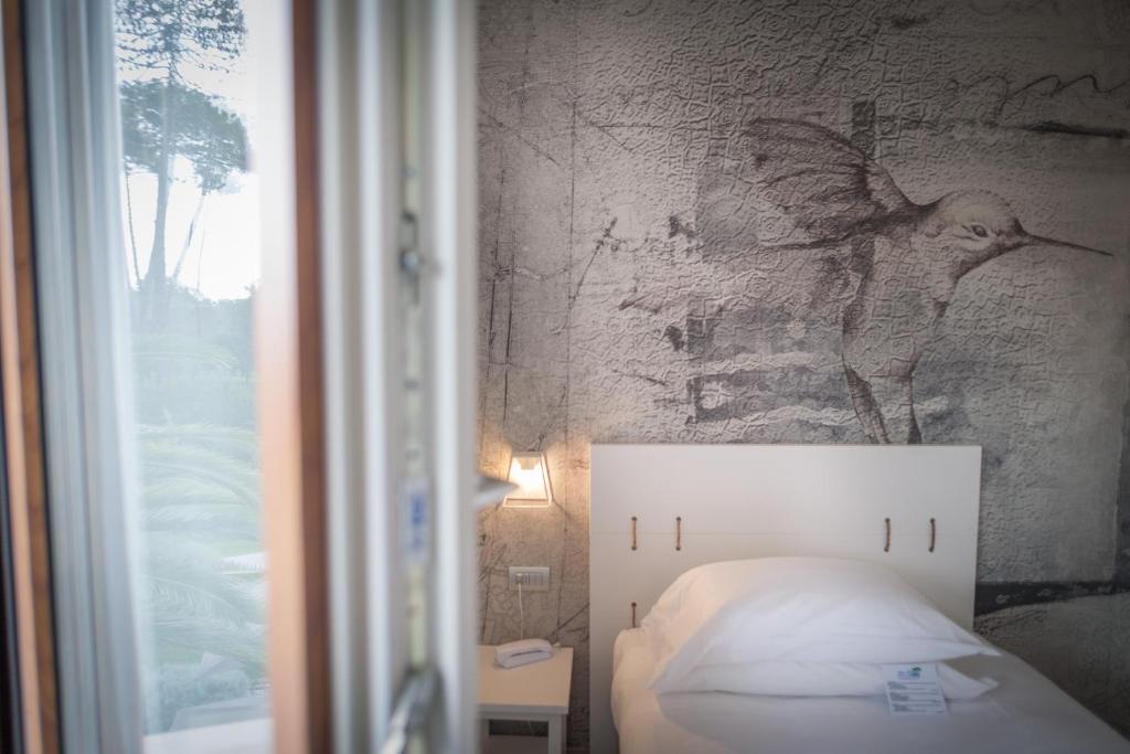 a bedroom with a bed and a wall with a picture at Arli Hotel Hideaway Punta Ala - Adults Only in Punta Ala