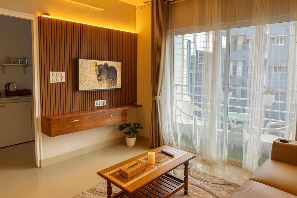 a living room with a table and a large window at NK Homes Fully Furnished Apts in Hyderabad