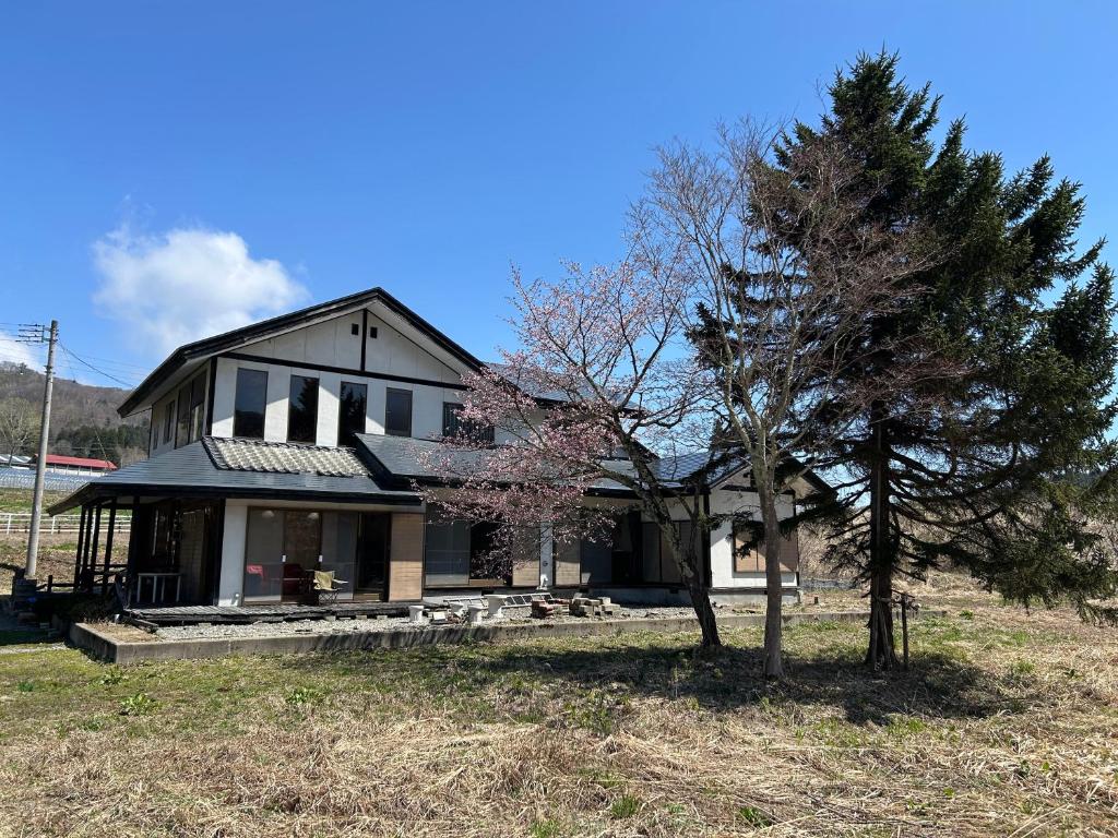 a house with a tree in front of it at Cool-Villa 飛騨リゾート in Hida