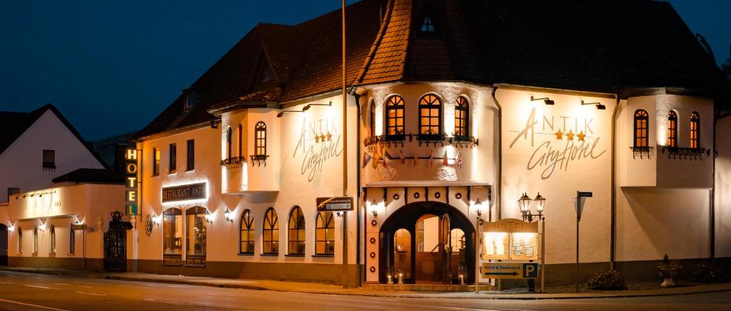 a large white building with lights on it at night at Boutiquehotel Goldhahn Bio Sport & Wellness in Aalen