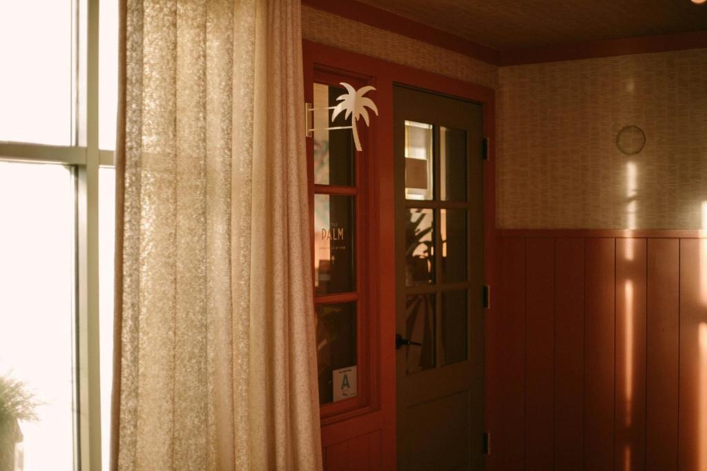 a door in a room with a window and a curtain at The Ryder Hotel in Charleston