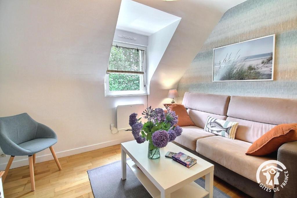 a living room with a couch and a table at La maison verte in Ploeuc