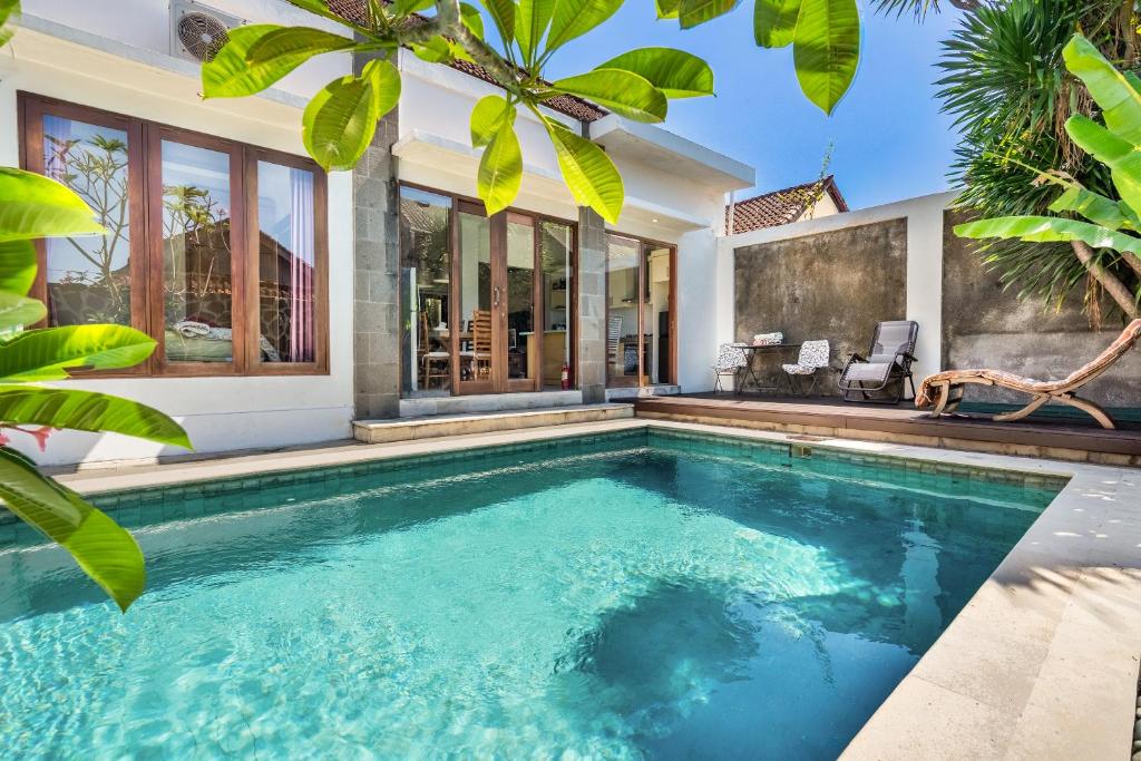 a swimming pool in front of a house at Casa Dijaweqo in Jimbaran