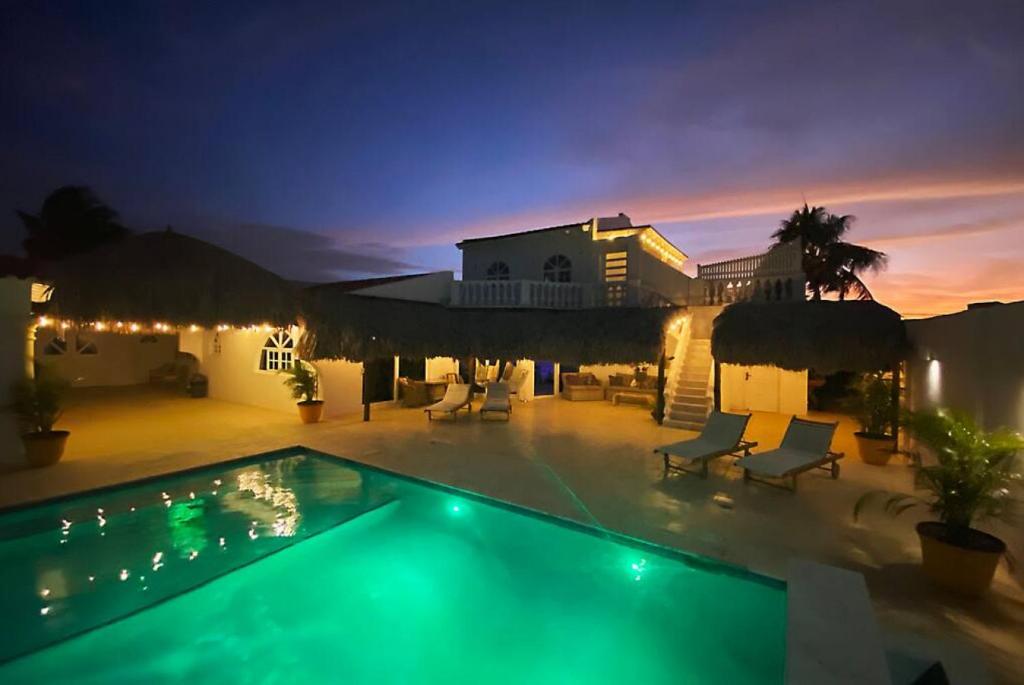 a villa with a swimming pool at night at Beach Walk Residences in Palm-Eagle Beach