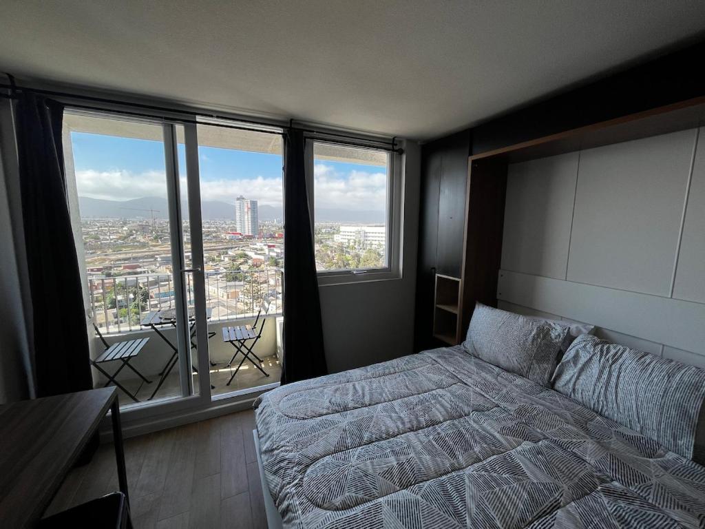 a bedroom with a bed and a view of a city at Despierta con una vista impecable cada mañana in Coquimbo