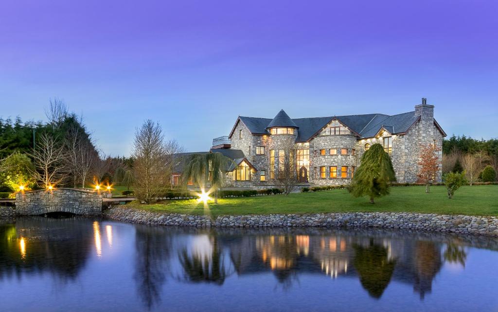 uma casa grande com um lago em frente em Castledale em Sligo