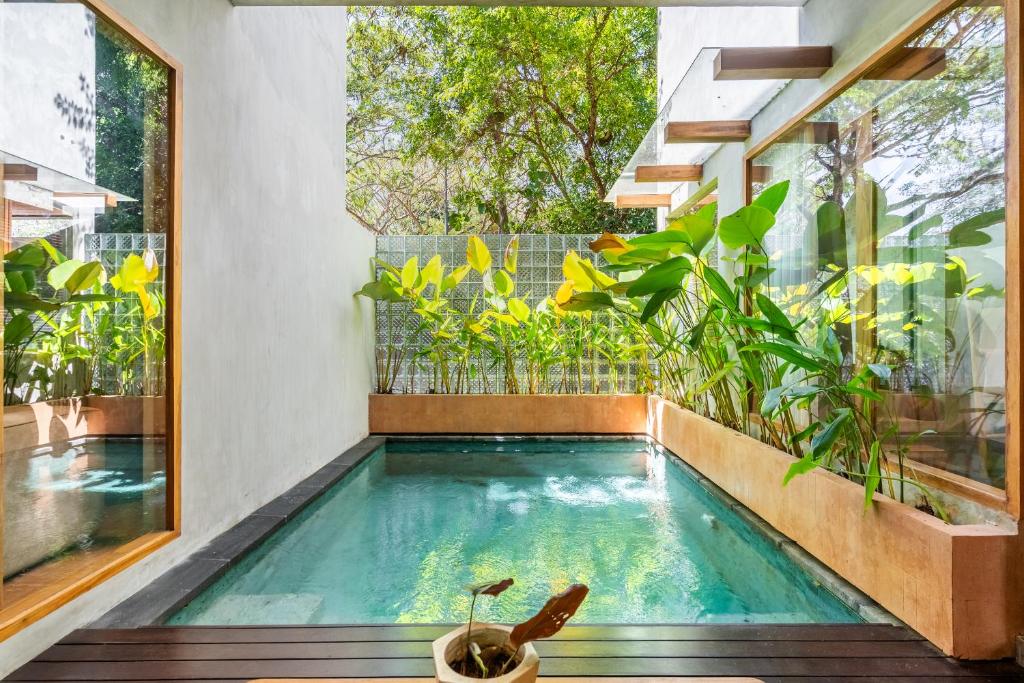 an indoor pool in a house with plants at Villa Dinova in Uluwatu