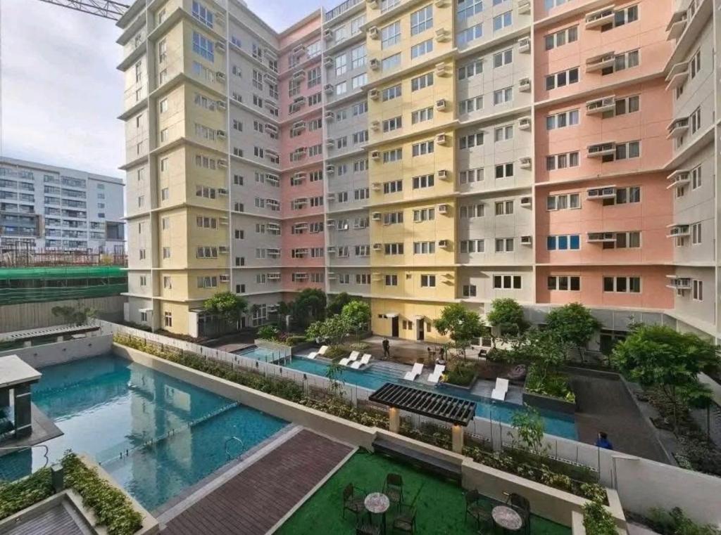 an apartment complex with a swimming pool in front of a building at Oasis 8 in Bacolod