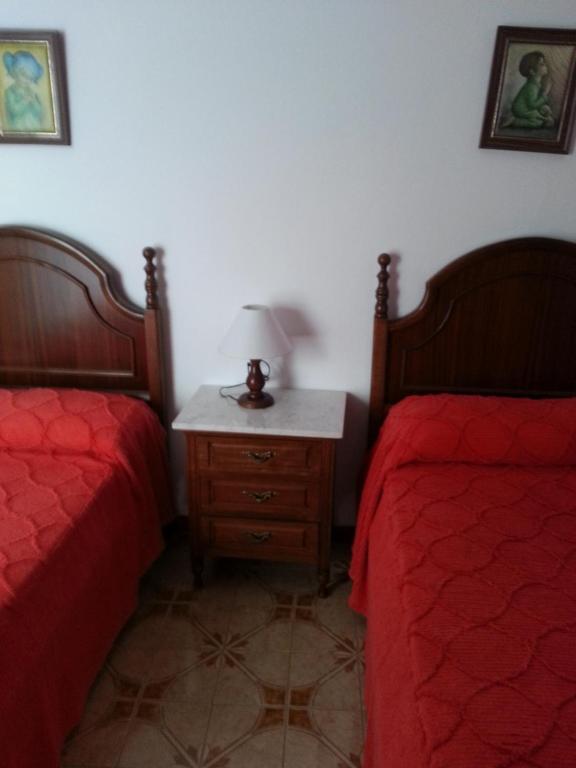 een slaapkamer met 2 bedden en een tafel met een lamp bij Casa Rural La Verdura in Ubrique