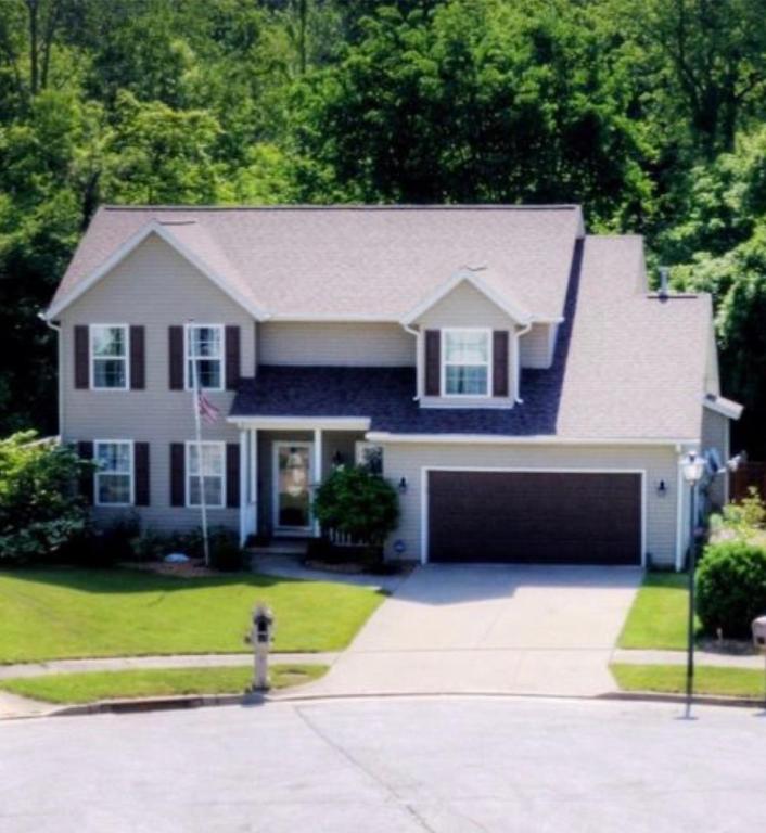 a house with a driveway and a garage at The Universal Home Stay in Akron