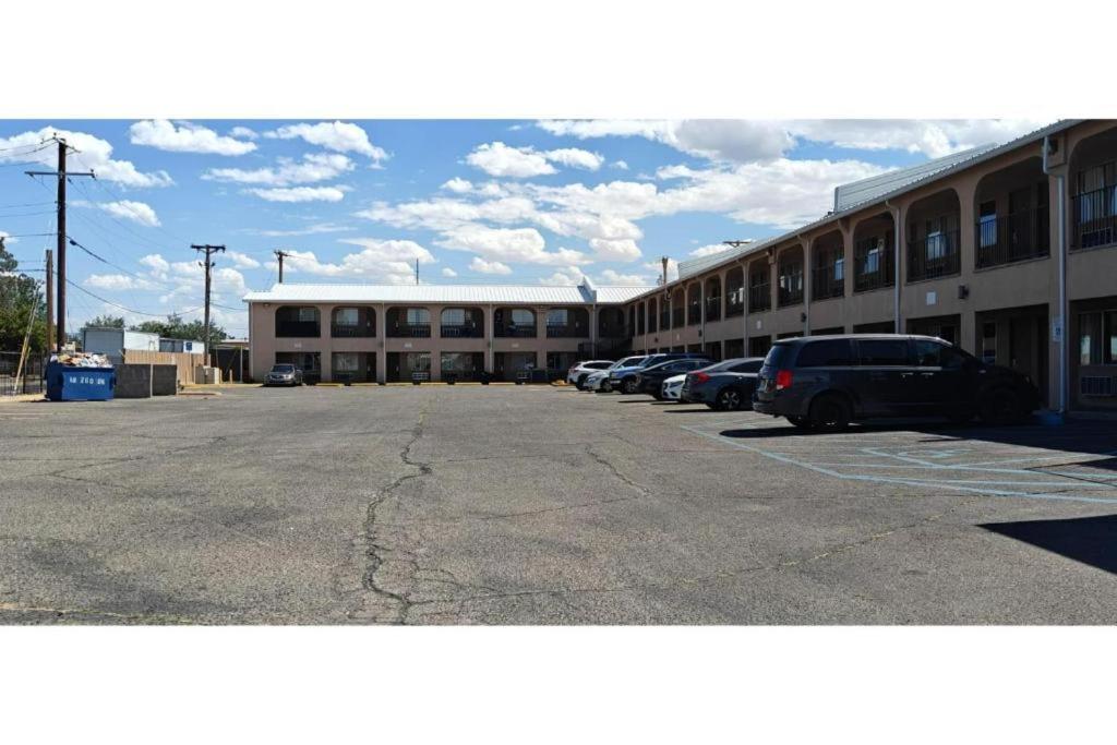 a parking lot with cars parked in front of a building at Albuquerque Inn in Albuquerque