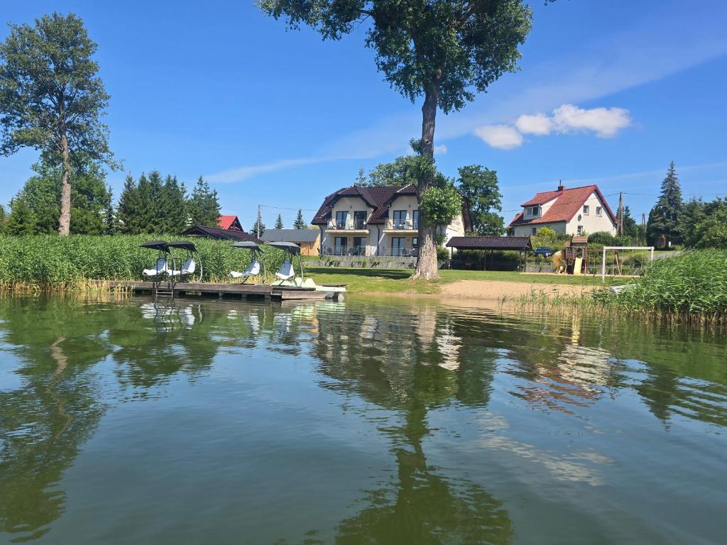 a large lake with a house in the background at Pokój Zełwągi in Mikołajki
