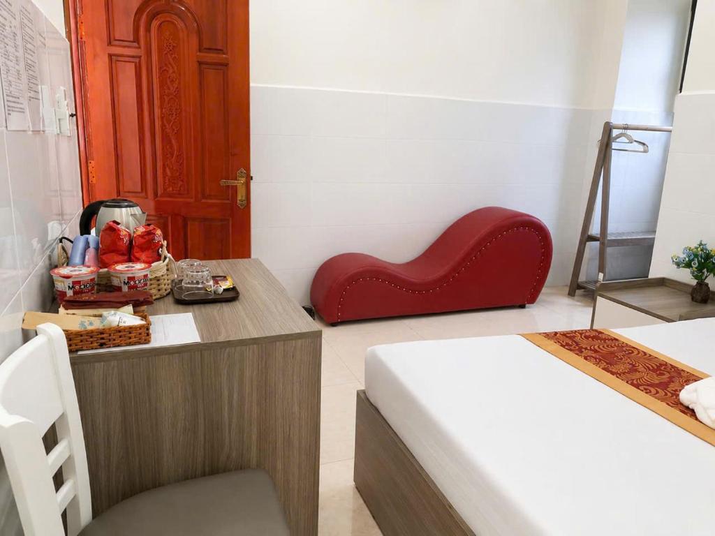 a room with a red heart chair next to a bed at Viora Hotel in Ấp Phước Thiện