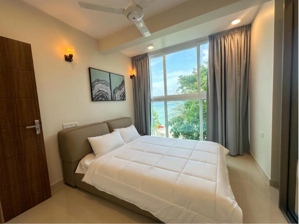 a bedroom with a large bed with a large window at The Oceanview Grand at Hulumale and Male in Hulhumale
