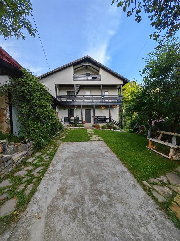a large house with a driveway in front of it at Casa Piatra Corbului in Gura Teghii