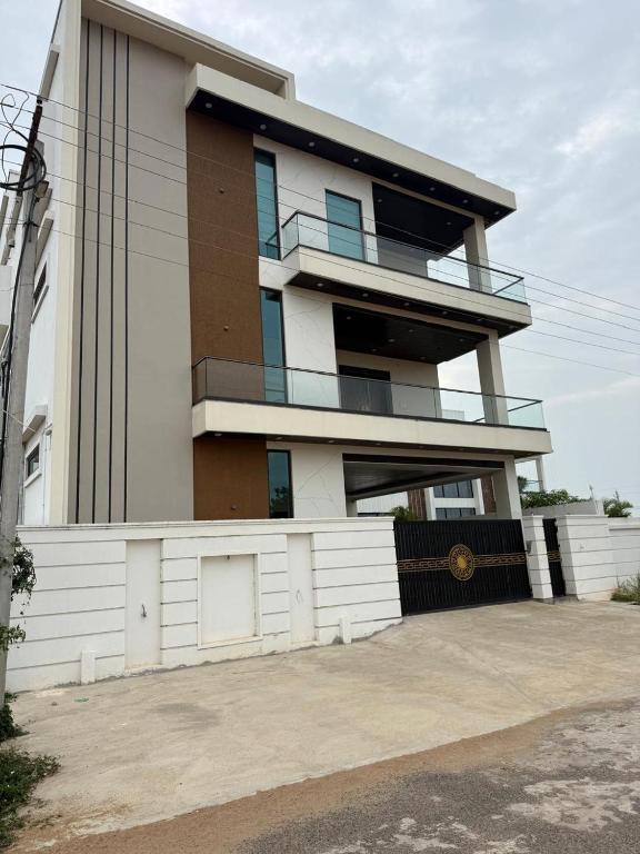 a large building with a fence in front of it at Happy homes in Elūru