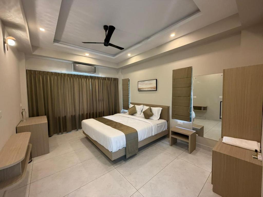 a bedroom with a bed and a bath room at Aamys Home in Kalpetta