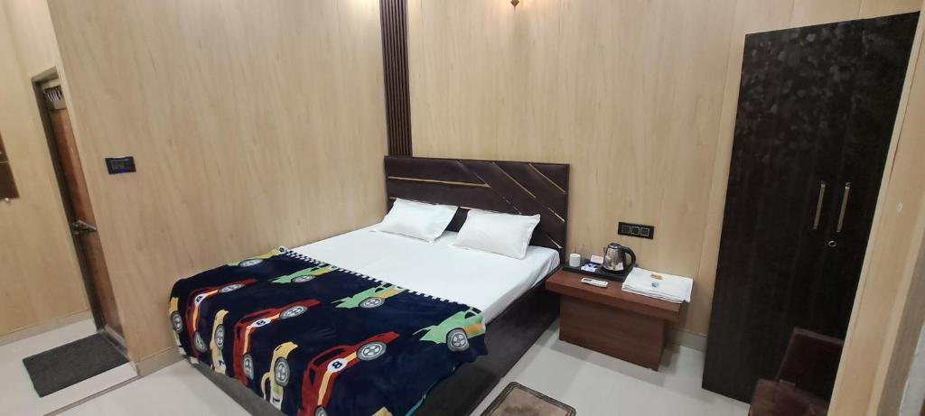 a bedroom with a bed and a night stand with a phone at Aashvi Guest House in Ayodhya