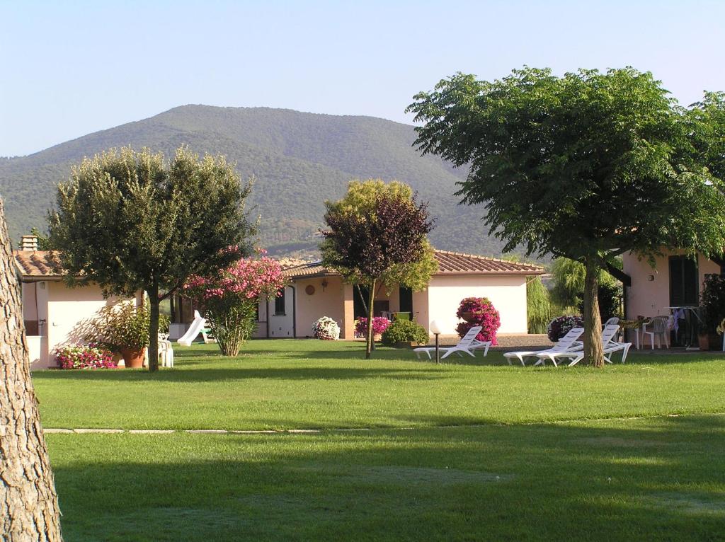 a group of people sitting on chairs in a yard at Agriturismo Bocci in Castiglione della Pescaia