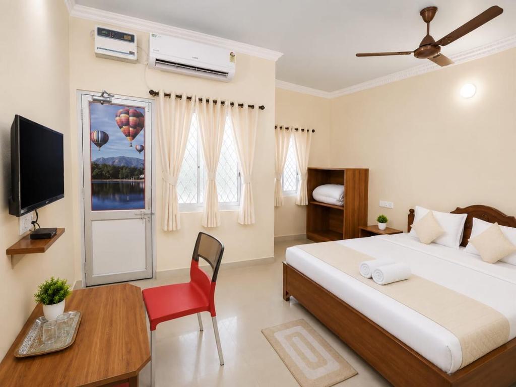 a bedroom with a bed and a desk and a television at Hotel Oceano in Puri