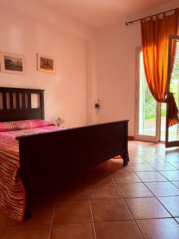 a bedroom with a bed and a large window at Ciuscia 0 in Calatabiano