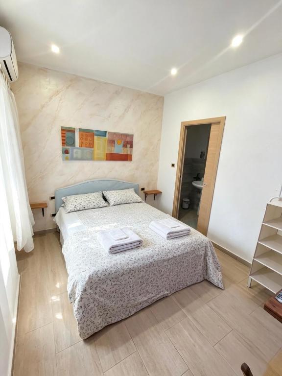 a bedroom with a bed with two towels on it at Il Faro Suites in Taranto