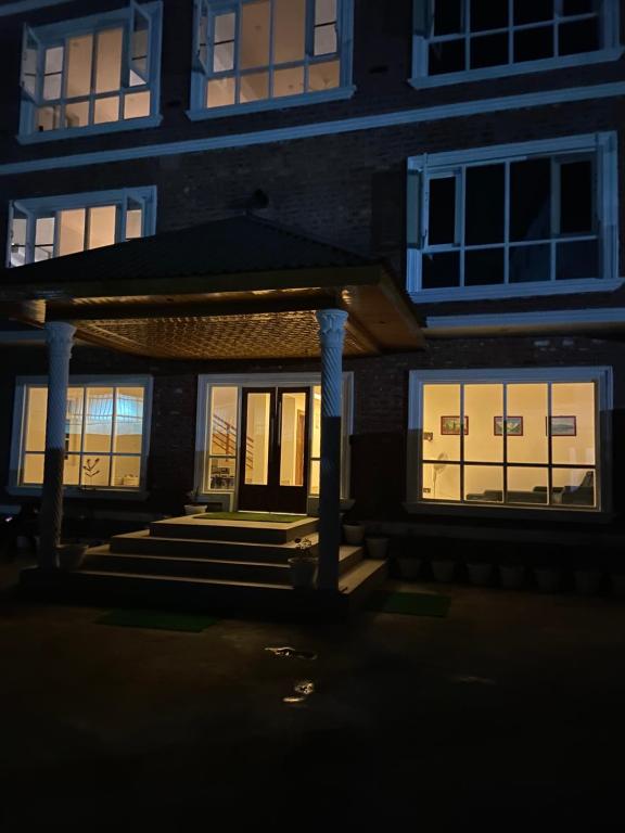 a house with its doors lit up at night at Haven Retreat in Srinagar