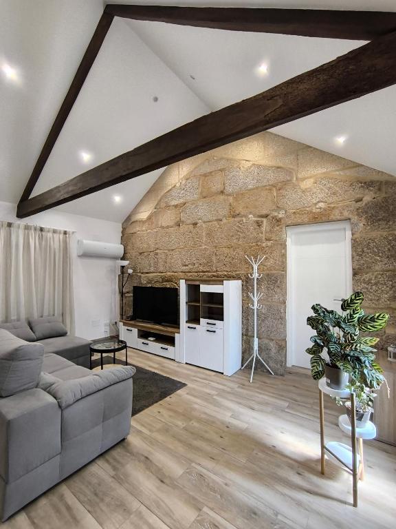 a living room with a large stone wall at Casa Fontenlos in Tui