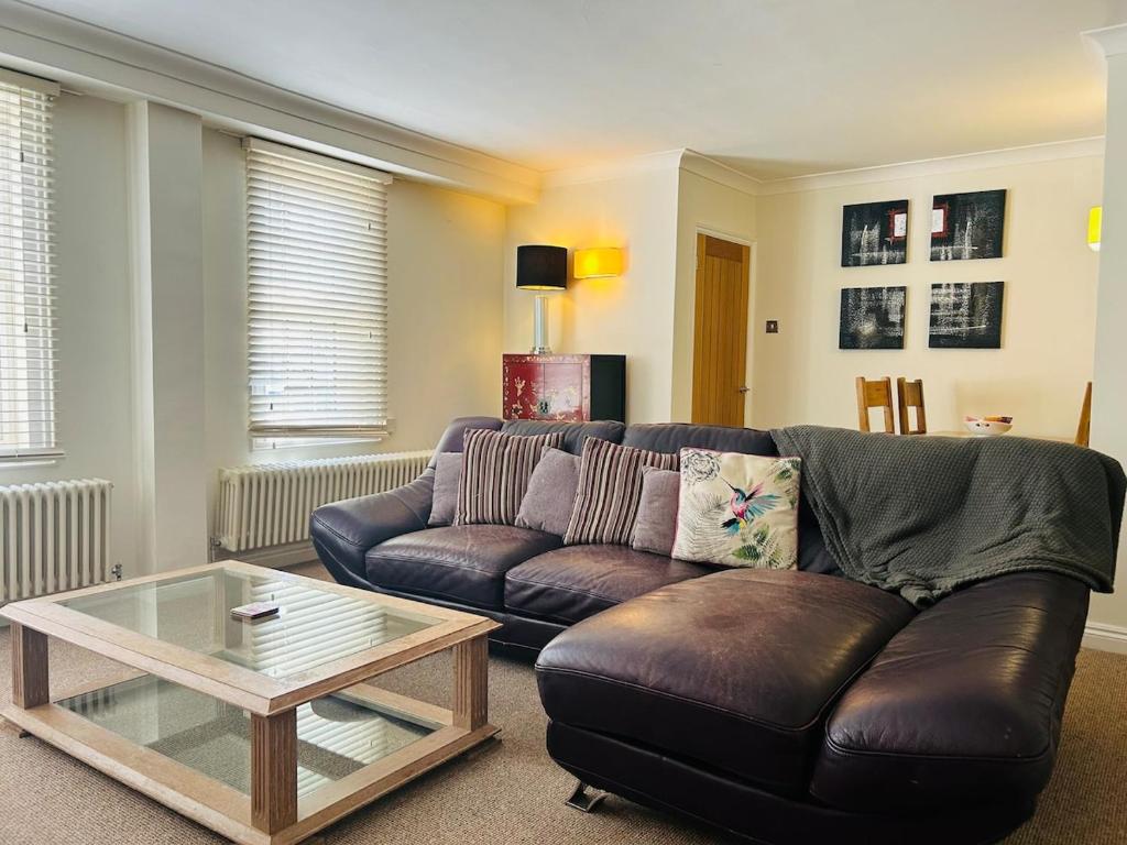 a living room with a leather couch and a coffee table at Benson House Box in Box
