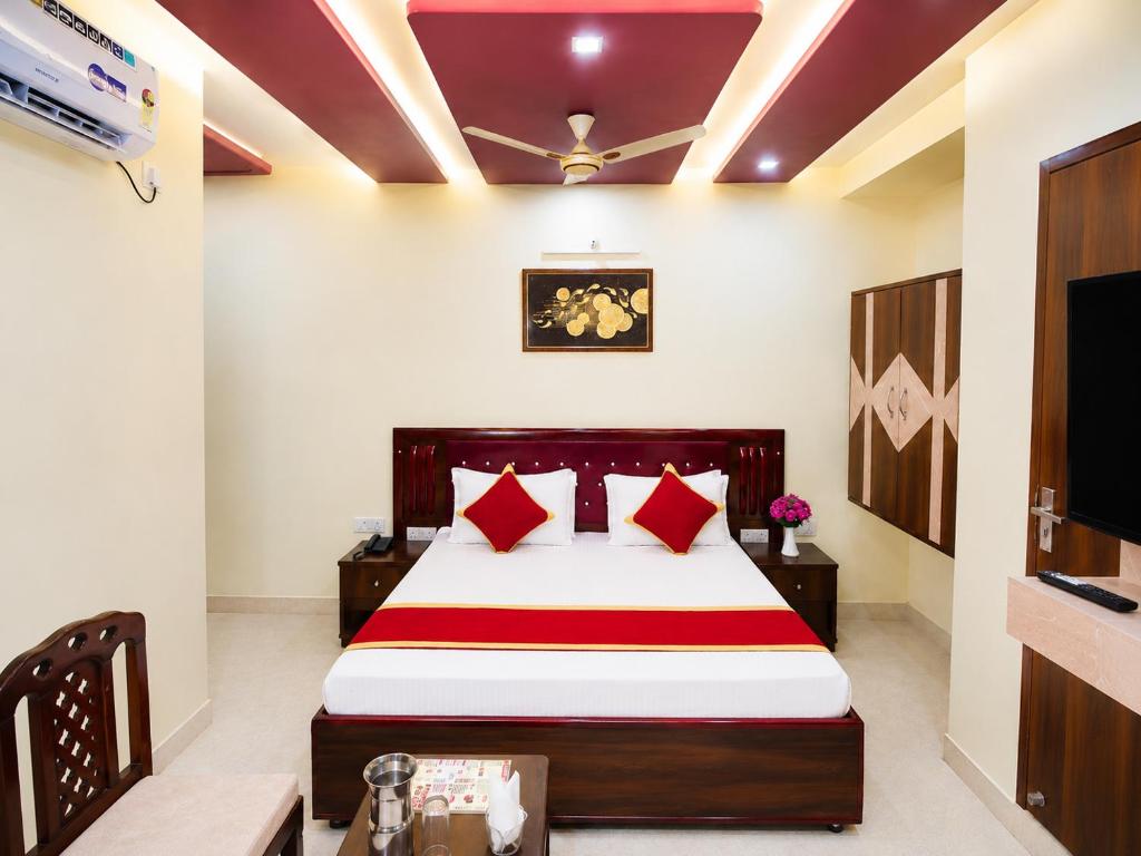 a bedroom with a large bed with red pillows at Hotel Pragati Palace in Mathura