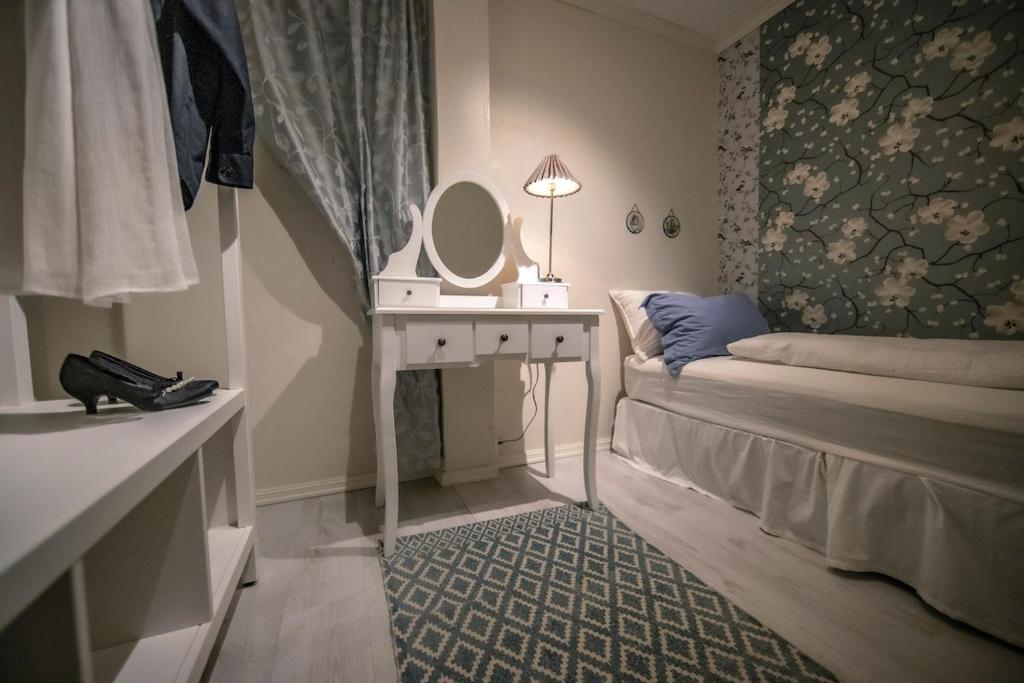 a bedroom with a bed and a dressing table with a mirror at Auntie Laurentze's house in Haugesund