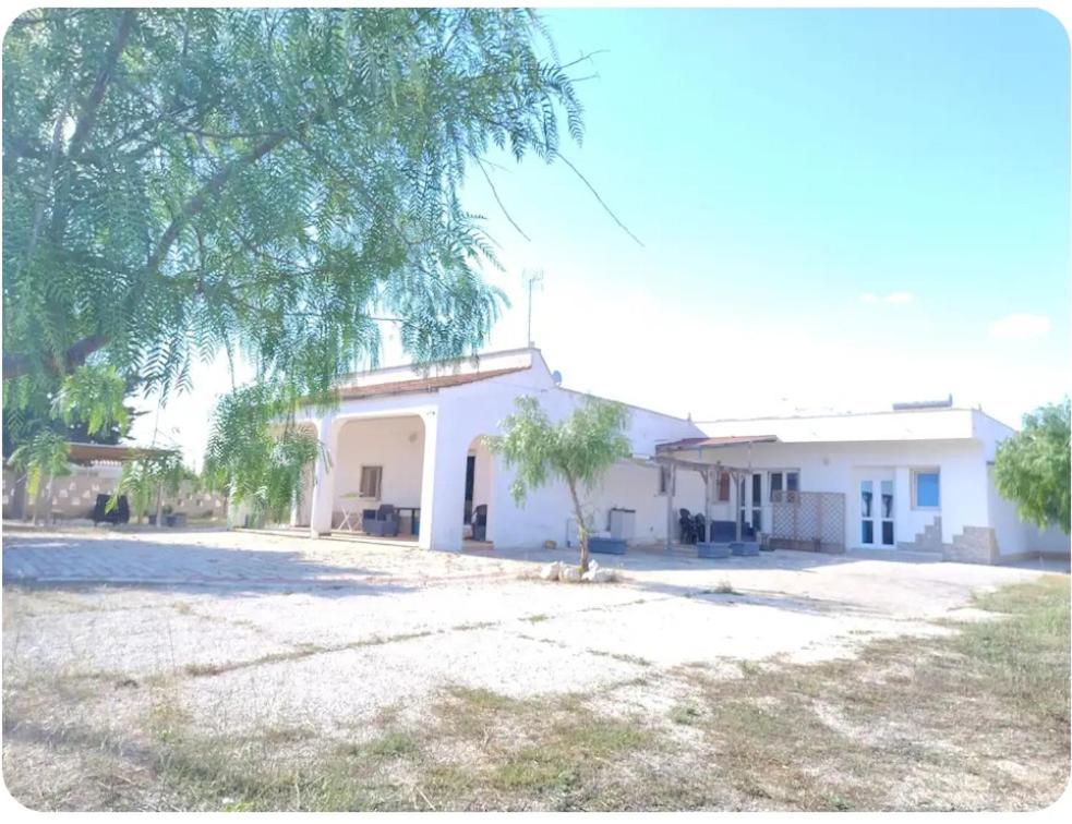 a white building with a tree in front of it at Villa Florence apartment con parcheggio in Torre Lapillo