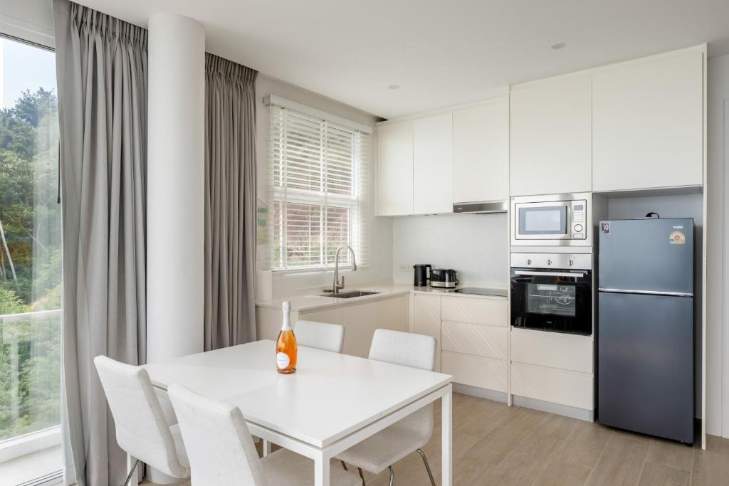 a white kitchen with a white table and chairs at Mountain and Sea view apartment in Nathon Bay