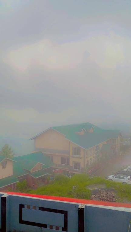 a view of a building on a foggy day at The Skyline Cottage in Nathia Gali