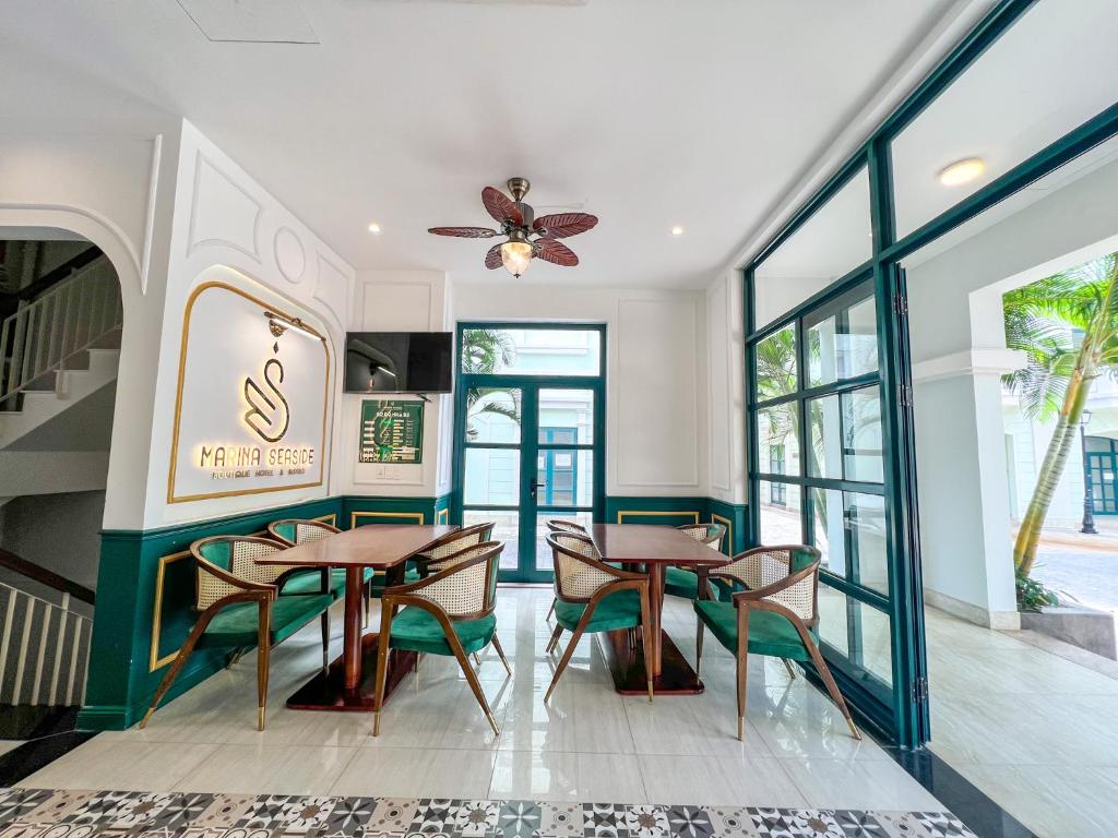a dining room with tables and chairs and windows at MARINA SEASIDE BEACH BOUTIQUE Phu Quoc - Infinity Pools - PREMIUM SOLAR ENERGY in Phú Quốc
