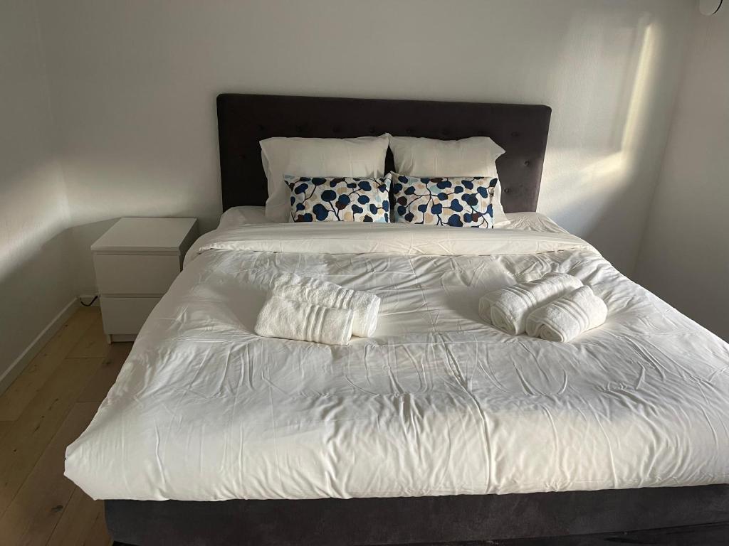 a bed with white sheets and pillows on it at Family home in Greve