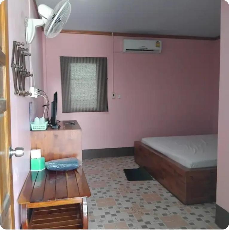 a bedroom with a bed and a table in a room at Saran Resort room 1 in Ban Khok Wat