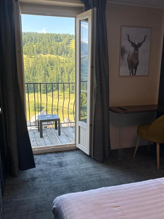 a hotel room with a door open to a balcony at Hôtel Génépi in Beuil