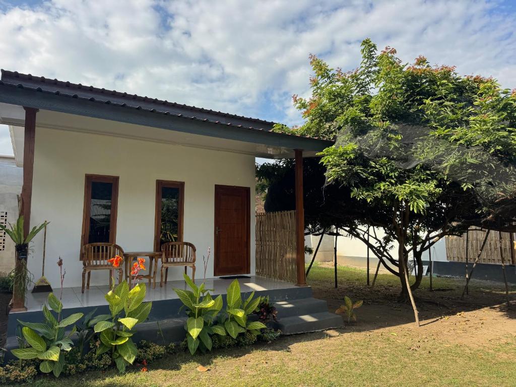 a small house with a table and chairs in a yard at JHOB Surf Stay in Maluk