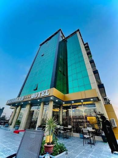 HAMDAN Hotel في هرجيسا: مبنى به طاولات وكراسي في واجهته