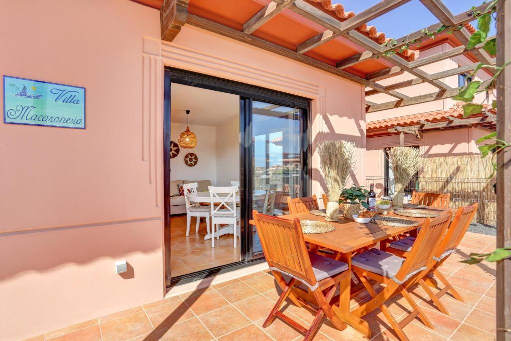 a dining room with a table and chairs on a patio at Villa Macaronesia Lajares Fuerteventura Remote work in Majanicho