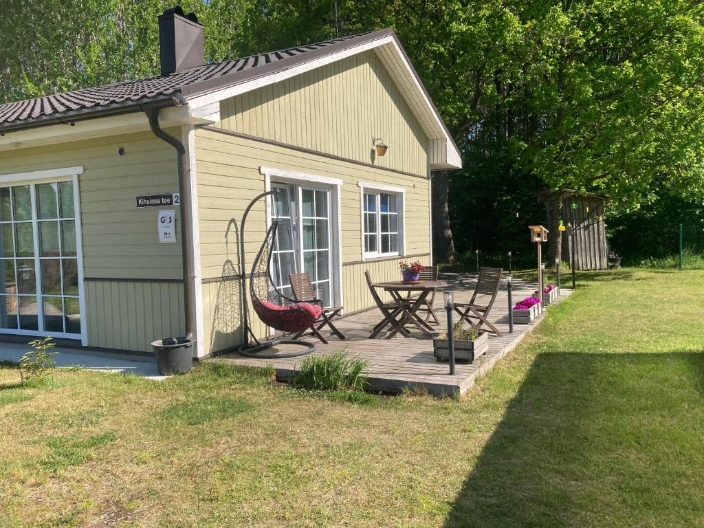 a house with a wooden deck with a table and chairs at Kihulase maja in Luigu