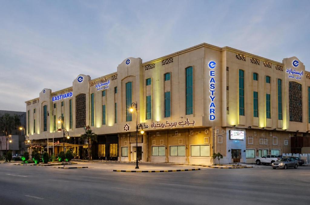 a large building with a parking lot in front of it at Eastyard Dammam Hotel in Dammam