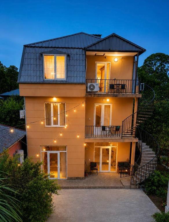 a large house with a staircase in front of it at Guest House Leon in Batumi