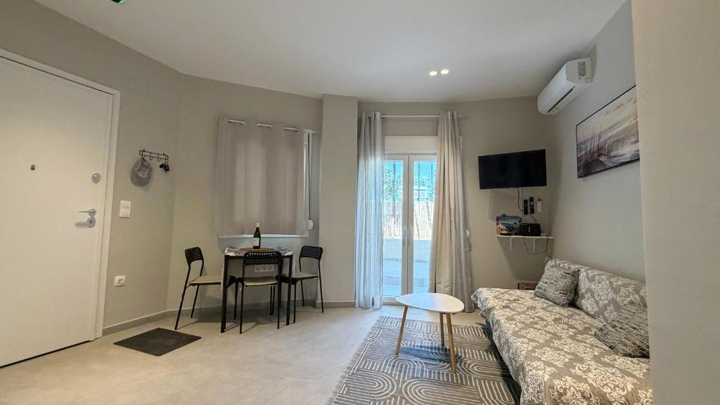 a living room with a couch and a table at Magdalena Elegant Studios in Neoi Epivates