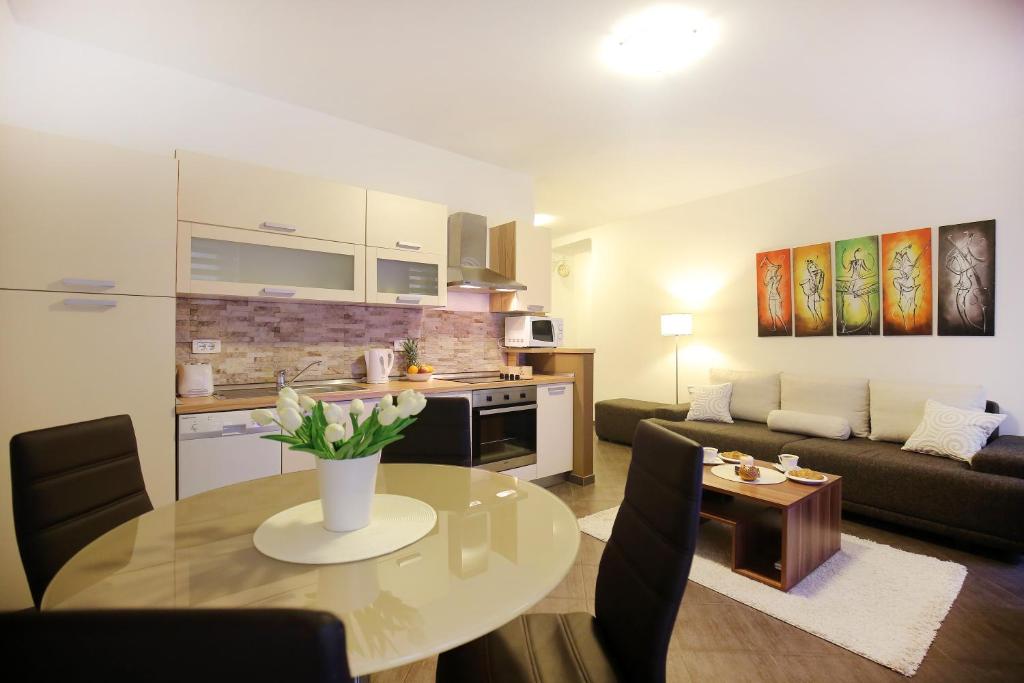 een keuken en een woonkamer met een tafel en een bank bij Allegro Exclusive Suites in Zadar