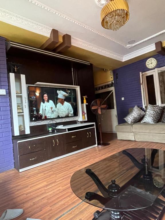 a living room with a tv with two chefs on it at Patan Nest in Pātan