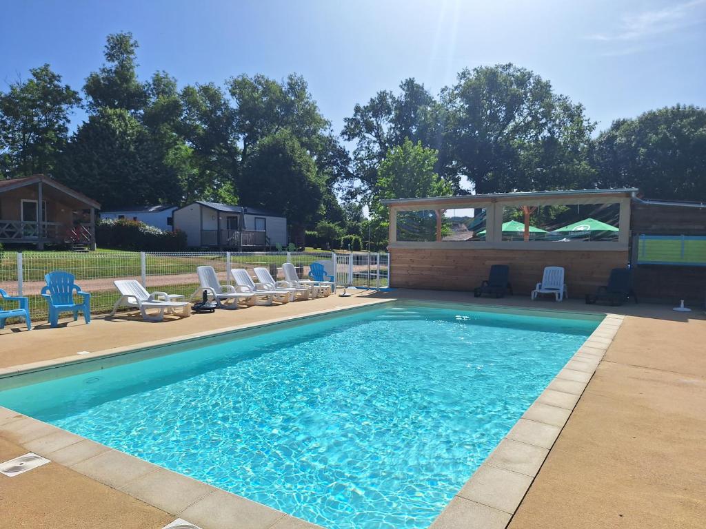 a swimming pool with chairs and a gazebo at Camping des Papillons in Lalizolle