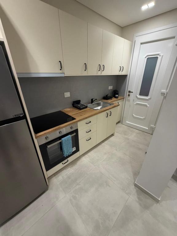 a small kitchen with white cabinets and a sink at HOME stay in Itea