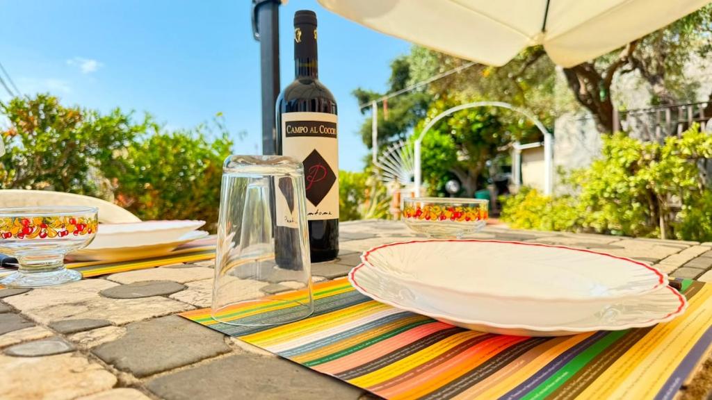 a table with a bottle of wine and a plate at I mille Tramonti di Ilaria in Livorno
